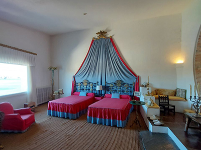 Bedroom inside Salvador Dalí's House in Portlligat, featuring two single beds and a window with a sew view