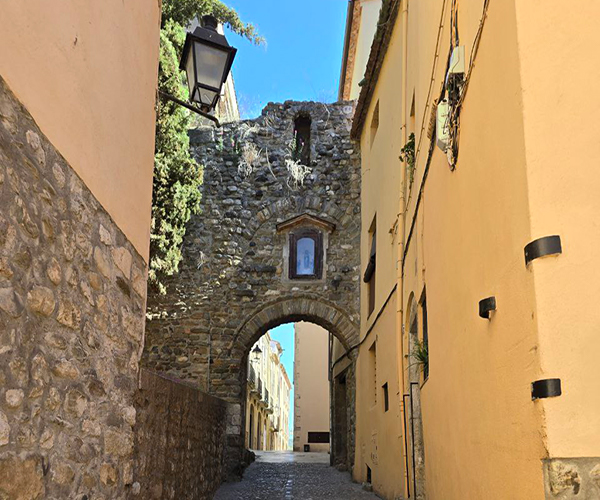 Narrow cobbled street in Besalú, lined with historic stone buildings