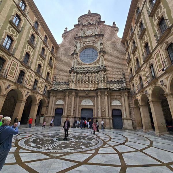 Front facade of the Basilica of Montserrat with intricate stone carvings