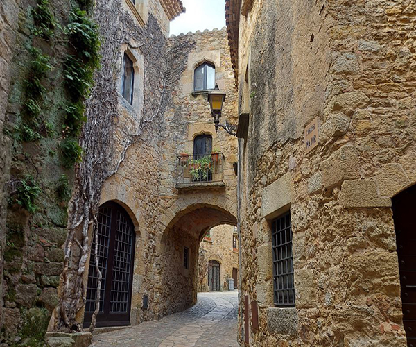 Stone medieval archway leading into the historic village of Pals